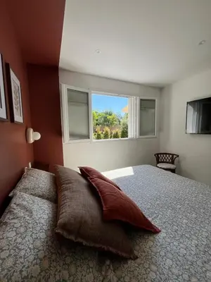 a bedroom with a large bed with a window at Rez-de-villa avec terrasse privative sur jardin in Ajaccio