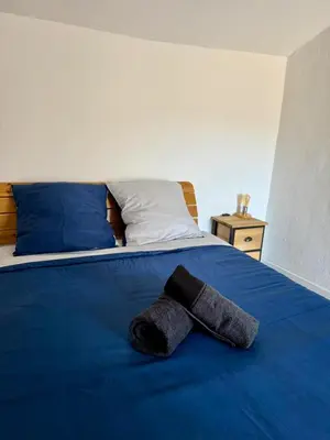 a hat laying on top of a blue bed at Tour avec rooftop, vue mer, séjour insolite entre ciel et mer in Porri