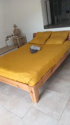 a bed with a yellow blanket on top of it at Tour avec rooftop, vue mer, séjour insolite entre ciel et mer in Porri