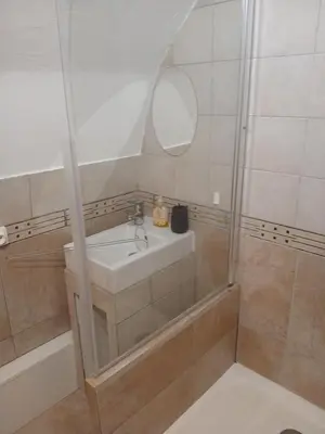 a bathroom with a sink and a shower with a mirror at Tour avec rooftop, vue mer, séjour insolite entre ciel et mer in Porri