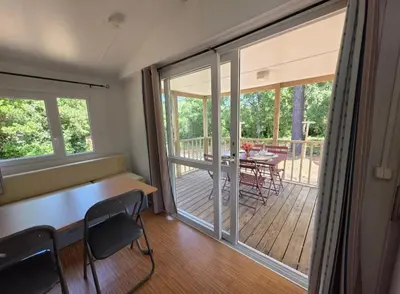 a room with a table and chairs on a deck at La Vigne in Lecci