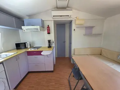 a small kitchen with white cabinets and a wooden table at La Vigne in Lecci