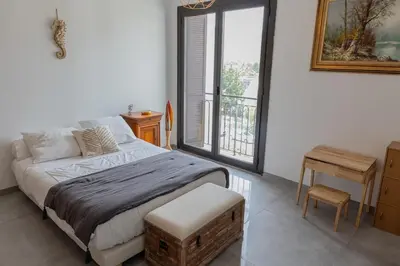 a bedroom with a bed and a table and a window at Sagone Appartement T3 in Coggia