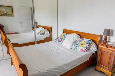 a bedroom with two beds and a mirror at Sagone Appartement T3 in Coggia