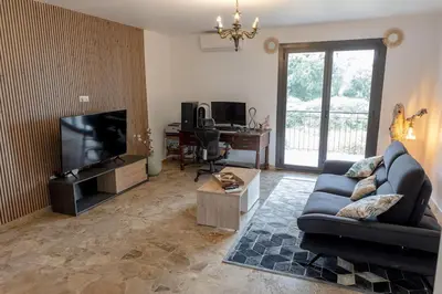 a living room with a couch and a television at Sagone Appartement T3 in Coggia