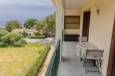 a balcony with a table and a view of a yard at Sagone Appartement T3 in Coggia
