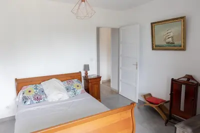 a bedroom with a bed and a chair at Sagone Appartement T3 in Coggia