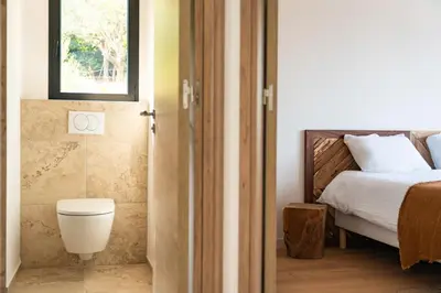 a bedroom with a bed and a toilet and a window at Bergerie entre plage et maquis in Zonza
