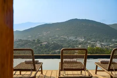 three chairs on a deck with a view of a mountain at Bergerie entre plage et maquis in Zonza