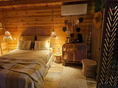 a bedroom with a bed and a wooden wall at Le cabanon de casaOma in Prunelli-di-Fiumorbo