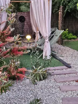a garden with a patio umbrella and a table at Le cabanon de casaOma in Prunelli-di-Fiumorbo