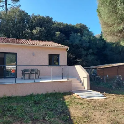 a house with a patio with a table on it at Clos Jeannette Villa près de la plage de Pinarelle et des piscines naturelles du Cavu in Zonza