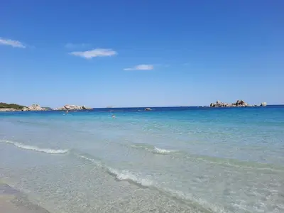a beach with the ocean and a blue sky at Clos Jeannette Villa près de la plage de Pinarelle et des piscines naturelles du Cavu in Zonza