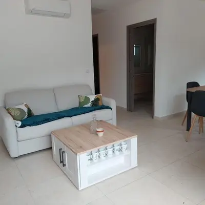a living room with a couch and a coffee table at Clos Jeannette Villa près de la plage de Pinarelle et des piscines naturelles du Cavu in Zonza