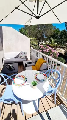 a white table and chairs on a deck with an umbrella at Fiori di Cala Rossa Signature in Lecci