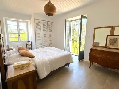 a bedroom with a bed and a table and a mirror at Villa Padulone in Aléria