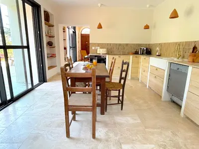 a kitchen with a wooden table and chairs at Villa Padulone in Aléria