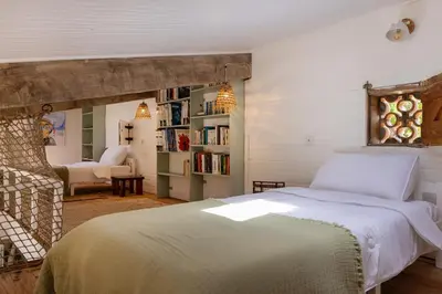 a bedroom with a white bed and a chair at Signura, maison entre mer et maquis in Piana