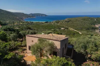a house on a hill with the ocean in the background at Signura, maison entre mer et maquis in Piana