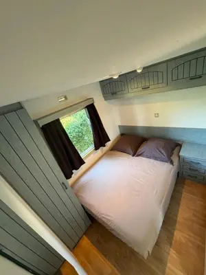 a bed in a tiny house with a window at I Dui Quarci in Prunelli-di-Fiumorbo