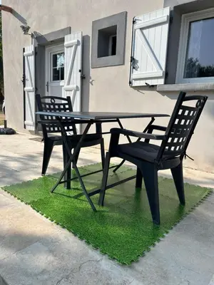 a picnic table and two chairs in front of a building at Casa Nustrali in Alata