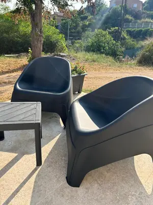 a black couch and a table next to a tree at Casa Nustrali in Alata