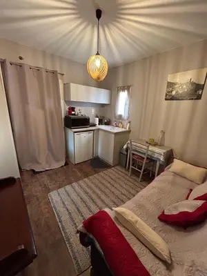 a bedroom with a bed and a small kitchen at Casa Nustrali in Alata