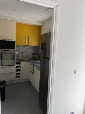 a kitchen with stainless steel appliances and yellow cabinets at La villa Timeo in Pietrosella