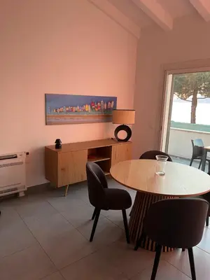 a room with a table and chairs and a window at La villa Timeo in Pietrosella