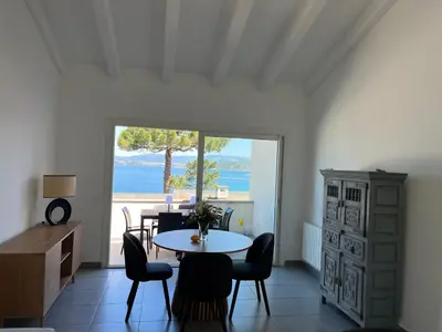 a dining room with a table and chairs and a window at La villa Timeo in Pietrosella