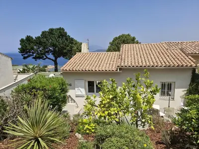 a white house with a tile roof at La villa Timeo in Pietrosella