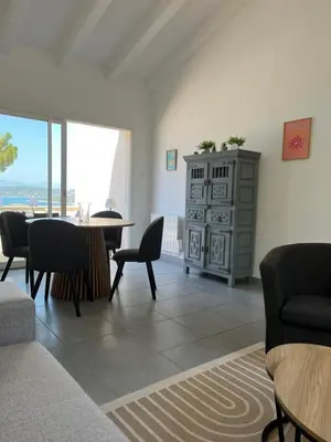 a living room with a table and chairs at La villa Timeo in Pietrosella
