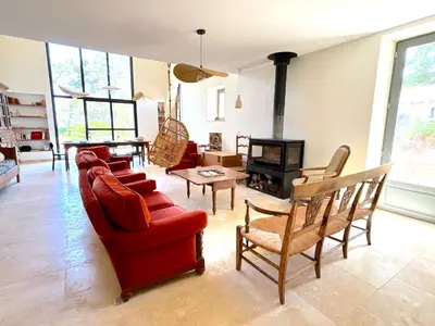 a living room with a red couch and a fireplace at L'appartement Vicente in Aléria