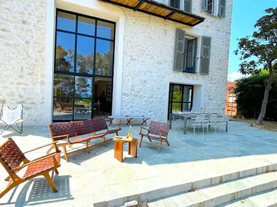 a patio with chairs and tables in front of a building at L'appartement Vicente in Aléria