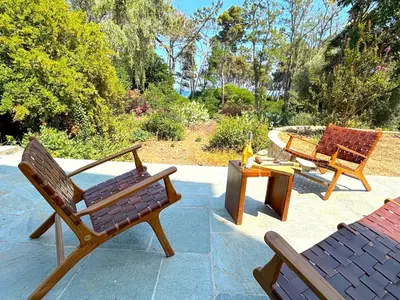 three wooden chairs and a table on a patio at L'appartement Vicente in Aléria