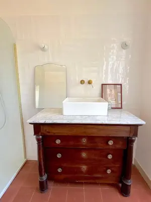 a bathroom with a sink and a mirror on a dresser at L'appartement Vicente in Aléria