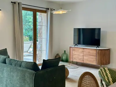 a living room with a couch and a flat screen tv at Casa di l'Ortu - Villa neuve avec piscine privée chauffée in Feliceto