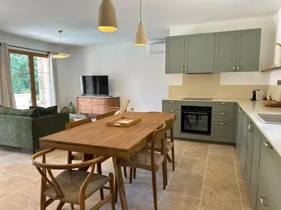 a kitchen with a wooden table and chairs in a room at Casa di l'Ortu - Villa neuve avec piscine privée chauffée in Feliceto