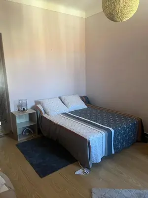 a small bedroom with a bed and a night stand at Appartement Centre-Ville Propriano in Propriano