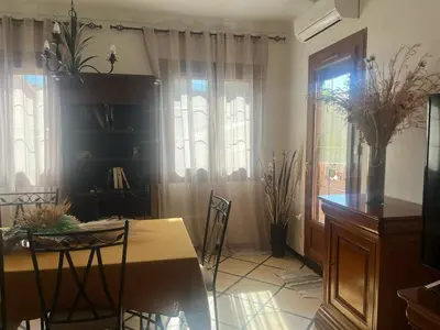 a living room with a table and chairs and windows at Appartement Centre-Ville Propriano in Propriano