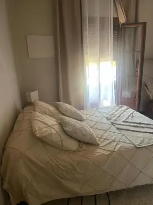 a bed with white sheets and pillows in a bedroom at Appartement Centre-Ville Propriano in Propriano