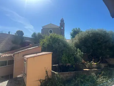 a building with a clock tower in the background at Appartement Centre-Ville Propriano in Propriano