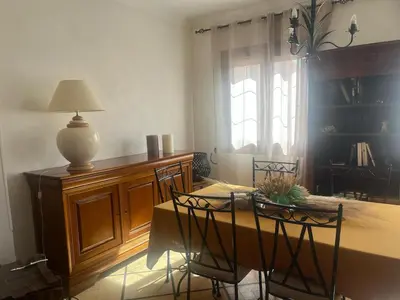 a dining room with a table and chairs and a lamp at Appartement Centre-Ville Propriano in Propriano