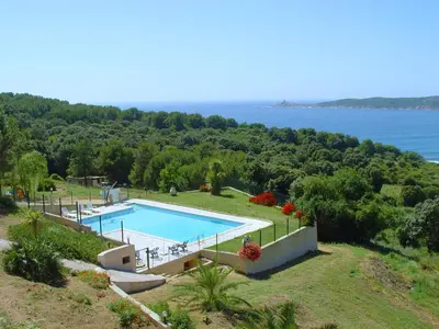 an estate with a swimming pool and the ocean at Appartement splendide vue mer in Cargèse