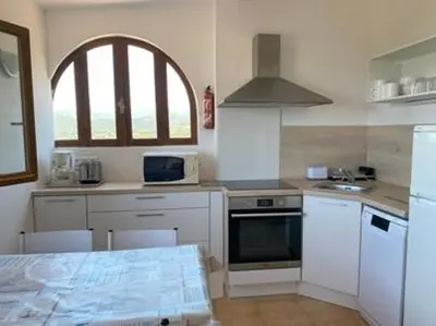 a kitchen with white appliances and a window in it at Appartement splendide vue mer in Cargèse