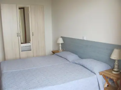 a bedroom with a blue bed with two lamps at Appartement splendide vue mer in Cargèse
