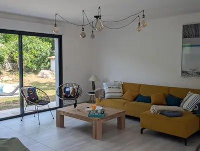 a living room with a yellow couch and a table at Maison climatisée de 3 chambres avec piscine privée in Sotta