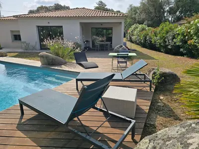 a patio with chairs and tables next to a pool at Maison climatisée de 3 chambres avec piscine privée in Sotta