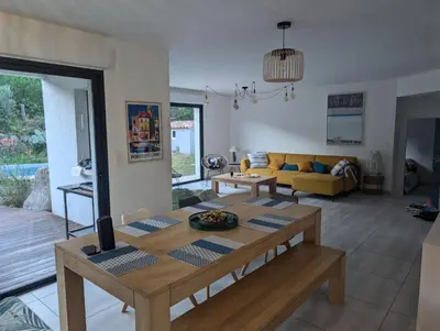 a living room with a table and a couch at Maison climatisée de 3 chambres avec piscine privée in Sotta