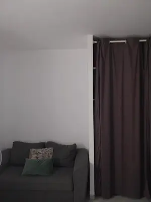 a living room with a couch and a curtain at Maison climatisée de 3 chambres avec piscine privée in Sotta